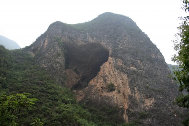 Mohutná jeskyně otevřená ve stěně vápencové hory.
