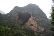 A huge cave opened in the face of a limestone mountain.